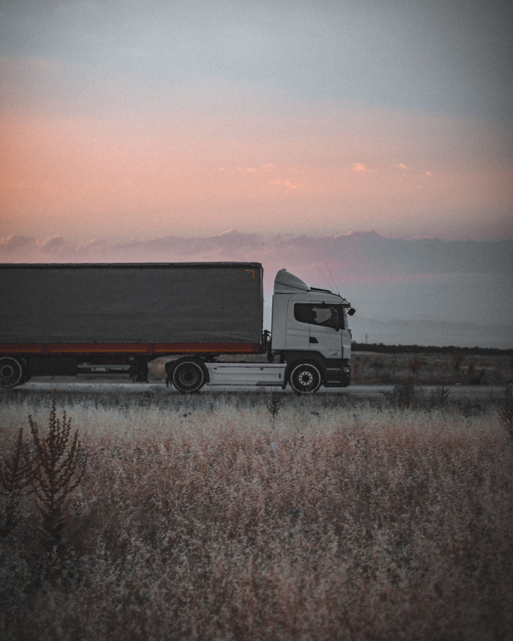 Freight truck traveling on an open route at dusk